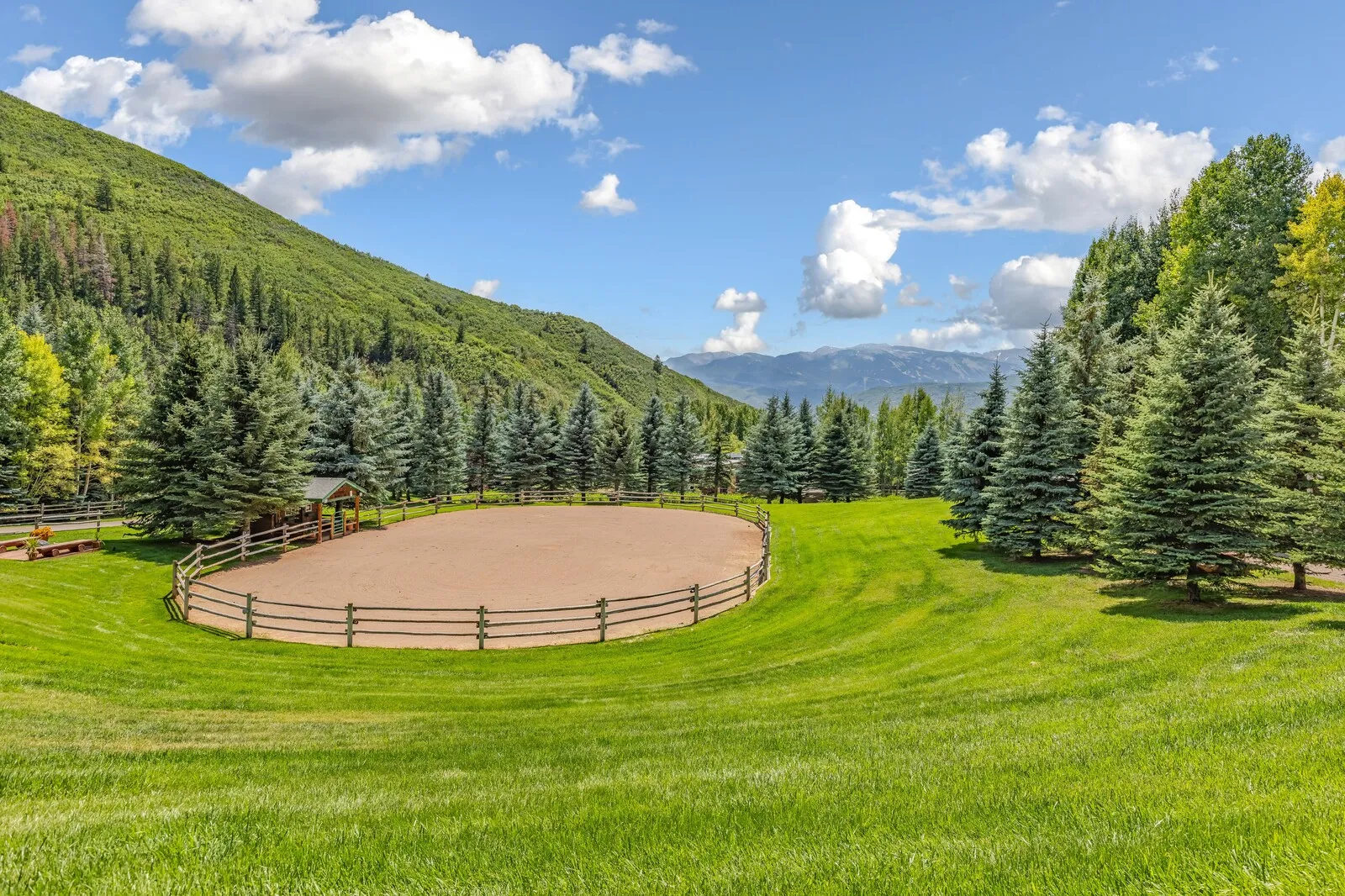 The riding arena in summer with the valley walls behind